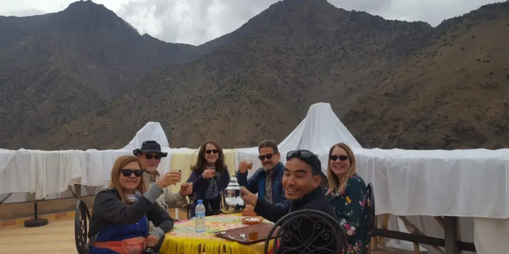 Berber family welcoming travelers with traditional mint tea in Morocco