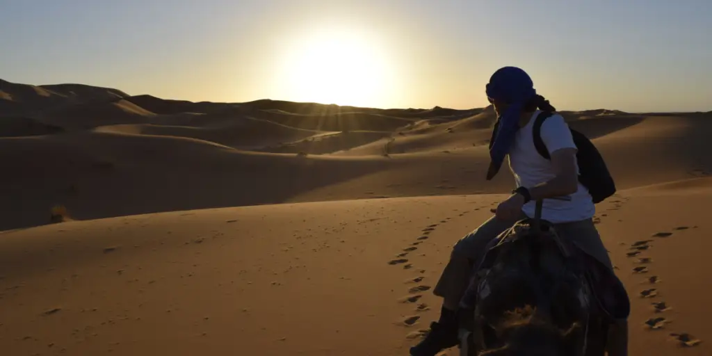 Travelers enjoying a camel riding experience at a Morocco desert camp
