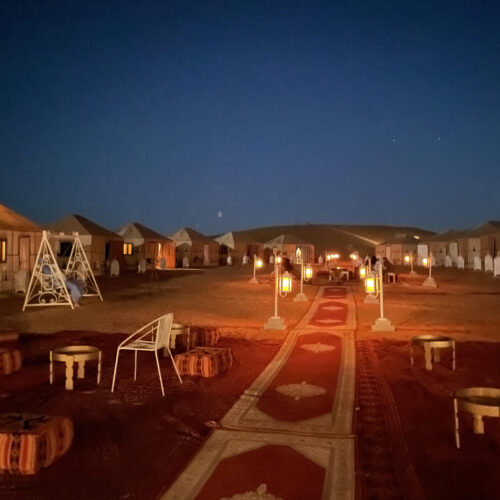 Desert camp surrounded by the golden dunes of Erg Chegaga in Morocco